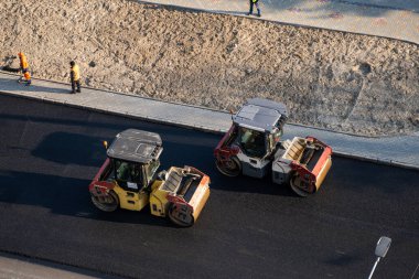 KYIV, UKRAINE - 10 Eylül 2020: Ağır asfalt yol silindirli ağır titreşimli paten sıkıştırıcısı, bir cadde üzerindeki yol inşaatında yeni bir sıcak asfalta baskı yapıyor..