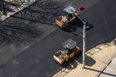 KYIV, UKRAINE - 10 Eylül 2020: Ağır asfalt yol silindirli ağır titreşimli paten sıkıştırıcısı, bir cadde üzerindeki yol inşaatında yeni bir sıcak asfalta baskı yapıyor..