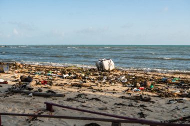 KOH SAMUI, THAILAND - 15 Aralık 2019: Plastik şişeler ve Koh Samui adasındaki deniz kıyısındaki diğer çöpler gibi plaj kirliliği. Bu çöpler deniz suyuyla kıyıya savruldu..