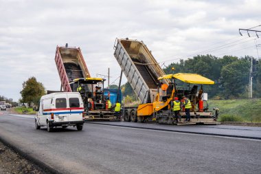 KYIV, UKRAINE - 25 Eylül 2020: Karayolu şantiyesine yeni asfalt döşeyen endüstriyel asfalt kaldırım makinesi.