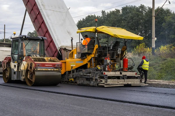 KYIV, UKRAINE - 25 września 2020: Przemysłowa nawierzchnia asfaltowa układająca świeży asfalt na budowie dróg. — Zdjęcie stockowe