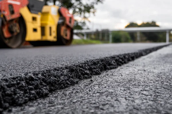 KYIV, UKRAINE - 25 września 2020: Dwa ciężkie asfaltowe rolki drogowe z ciężkim zagęszczaczem walców wibracyjnych, które naciskają nowy gorący asfalt na jezdni na placu budowy dróg na ulicy. — Zdjęcie stockowe