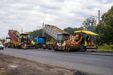 KYIV, UKRAINE - 25 Eylül 2020: Karayolu şantiyesine yeni asfalt döşeyen endüstriyel asfalt kaldırım makinesi.