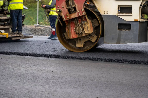 Asfalt road roller z ciężkimi wibracjami rolki zagęszczarki naciśnij nowy gorący asfalt na jezdni na placu budowy dróg. Ciężki wałek wibracyjny na asfaltowej nawierzchni działa. Naprawa. — Zdjęcie stockowe