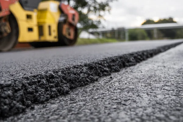 Asfalt vägvält med tung vibrationsvält komprimator pressa ny varm asfalt på vägbanan på en vägbygge. Heavy Vibration roller på asfalt trottoaren fungerar. Reparation. — Stockfoto