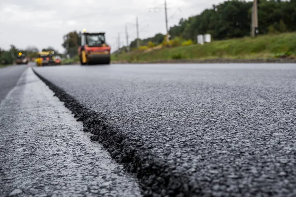 Asfalt road roller z ciężkimi wibracjami rolki zagęszczarki naciśnij nowy gorący asfalt na jezdni na placu budowy dróg. Ciężki wałek wibracyjny na asfaltowej nawierzchni działa. Naprawa. — Zdjęcie stockowe