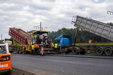KYIV, UKRAINE - 25 Eylül 2020: Karayolu şantiyesine yeni asfalt döşeyen endüstriyel asfalt kaldırım makinesi.