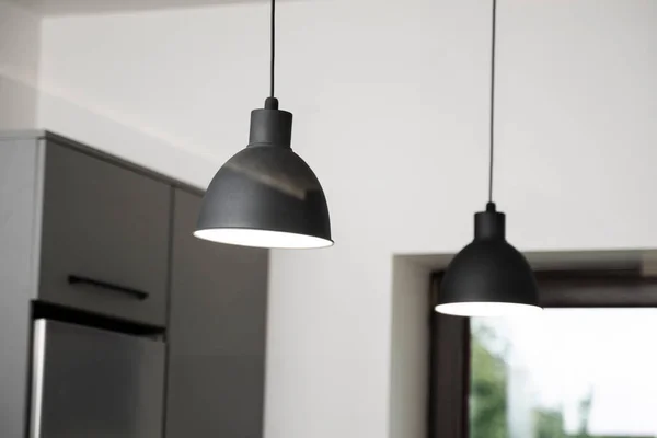 Industrial black look pendant lamps in a kitchen interior. Modern loft interior design.