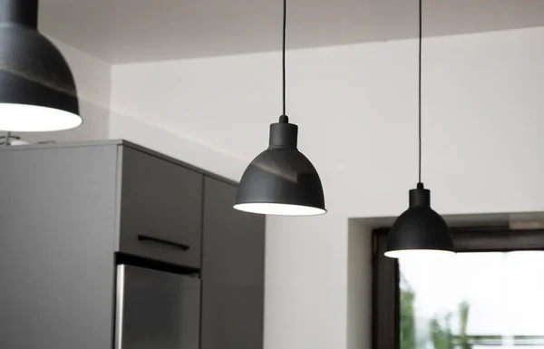 Industrial black look pendant lamps in a kitchen interior. Modern loft interior design.