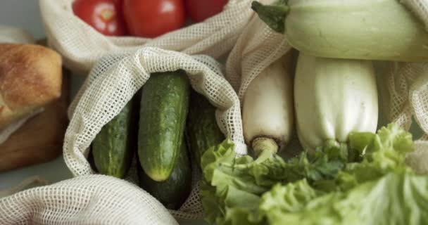 Verdure, frutta in sacchetti di cotone eco riutilizzabili in tavola. Zero rifiuti concetto di shopping. Articoli gratuiti in plastica. Multi-uso, riutilizzo, riciclaggio. Borsa ecologica per la spesa in tela con pomodori, pepe, pane. — Video Stock