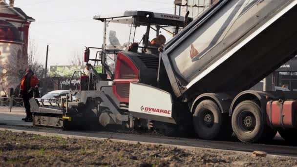 KYIV, UCRANIA - 10 de septiembre de 2020: Máquina de asfalto industrial que pone asfalto fresco en el sitio de construcción de carreteras en la calle. — Vídeo de stock