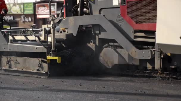 KYIV, UCRANIA - 10 de septiembre de 2020: Máquina de asfalto industrial que pone asfalto fresco en el sitio de construcción de carreteras en la calle. — Vídeo de stock