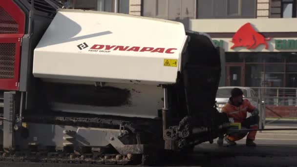 KYIV, UKRAINE - 10 september 2020: Industriële asfaltbestrating machine die vers asfalt legt op de weg bouwplaats op straat. — Stockvideo