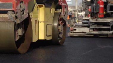 KYIV, UKRAINE - 10 Eylül 2020: Ağır asfalt yol silindirli ağır titreşimli paten sıkıştırıcısı, bir cadde üzerindeki yol inşaatında yeni bir sıcak asfalta baskı yapıyor..