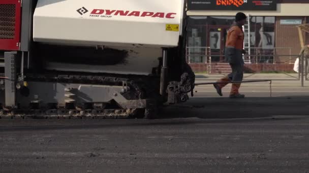 KYIV, UCRÂNIA - 10 de setembro de 2020: Máquina de paver asfalto industrial que coloca asfalto fresco no canteiro de obras rodoviárias na rua. — Vídeo de Stock