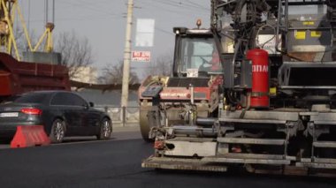 KYIV, UKRAINE - 10 Eylül 2020: Ağır asfalt yol silindirli ağır titreşimli paten sıkıştırıcısı yeni asfalt ve asfalt kaldırıcı makinesini bir sokak inşaatında çalıştırıyor.
