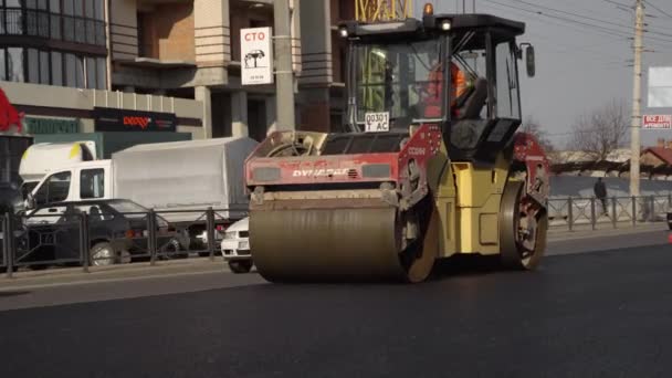 KYIV, UKRAINE - 10 september 2020: Tung asfalterad vägvält med tung vibrationsvält som pressar ny het asfalt på vägbanan på en vägbygge på en gata. — Stockvideo