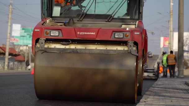 KYIV, UKRAINE - 2020 년 9 월 10 일: 도로 건설 현장의 도로 위에서 새로운 뜨거운 아스팔트를 누르는 무거운 진동형 롤러. — 비디오