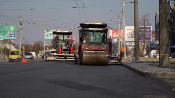 KYIV, UCRANIA - 10 de septiembre de 2020: Rodillo de carretera de asfalto pesado con compactador de rodillos de vibración pesada que presiona el nuevo asfalto caliente en la carretera en un sitio de construcción de carreteras en una calle. — Vídeos de Stock