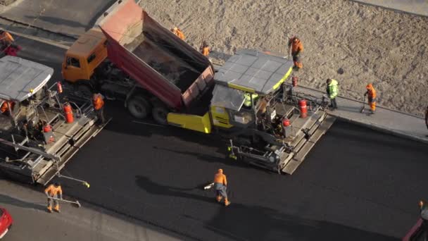 KYIV, UKRAINE - 10 september 2020: Zware asfaltwals met zware trilwals compactor die nieuwe hete asfalt en asfalt bestrating machine persen op een weg bouwplaats op een straat. — Stockvideo