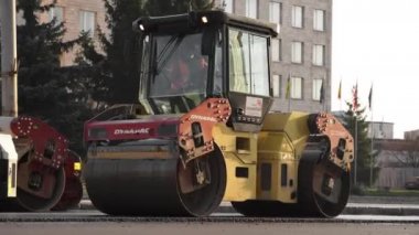 KYIV, UKRAINE - 10 Eylül 2020: Ağır asfalt yol silindirli ağır titreşimli paten sıkıştırıcısı, bir cadde üzerindeki yol inşaatında yeni bir sıcak asfalta baskı yapıyor..