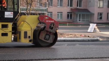 KYIV, UKRAINE - 10 Eylül 2020: Ağır asfalt yol silindirli ağır titreşimli paten sıkıştırıcısı, bir cadde üzerindeki yol inşaatında yeni bir sıcak asfalta baskı yapıyor..