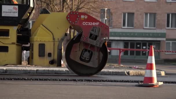 KYIV, UKRAINE - 10 septembre 2020 : Rouleau de route en asphalte lourd avec compacteur à rouleaux à vibrations lourdes qui presse du nouvel asphalte chaud sur la chaussée sur un chantier de construction routière dans une rue. — Video