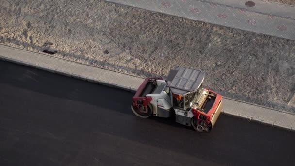 KYIV, UKRAINE - September 10, 2020: Heavy asphalt road roller with heavy vibration roller compactor that press new hot asphalt on the road way on a street construction site. — 图库视频影像