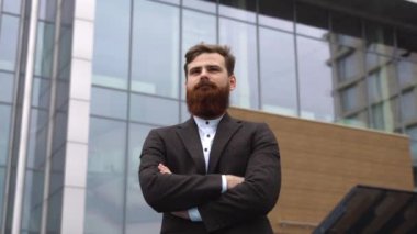 Finans bölgesindeki ofis binasında ceketli yakışıklı bir işadamının portresi. Genç sakallı iş adamı. Resmi giyinmiş başarılı bir girişimci..