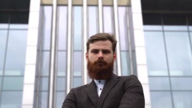 Finans bölgesindeki ofis binasında ceketli yakışıklı bir işadamının portresi. Genç sakallı iş adamı. Resmi giyinmiş başarılı bir girişimci..