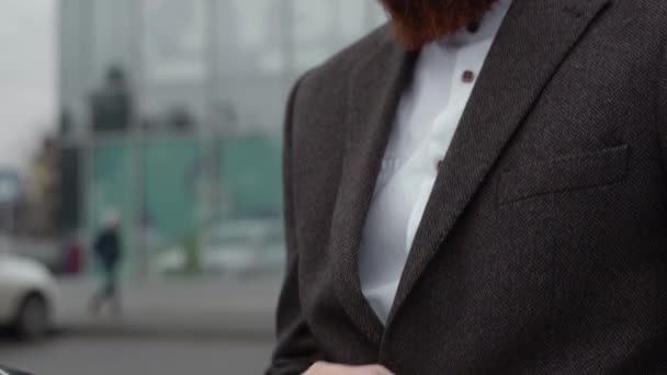 Ritratto di un bell'uomo d'affari che indossa una giacca sopra un edificio per uffici nel distretto finanziario all'aperto. Giovane uomo d'affari barbuto all'aperto. imprenditore di successo vestito in abbigliamento formale. — Video Stock