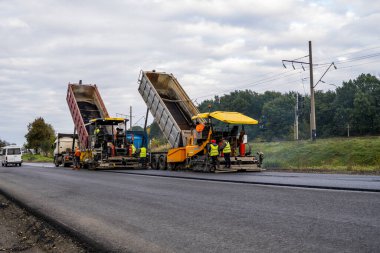 KYIV, UKRAINE - 25 Eylül 2020: Karayolu şantiyesine yeni asfalt döşeyen endüstriyel asfalt kaldırım makinesi.