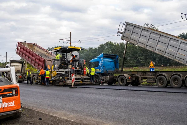 KYIV, UKRAINE - 25 września 2020:: Ciężki asfaltowy wałek drogowy z ciężkim zagęszczaczem wibracyjnym, który wciska nowy gorący asfalt i nawierzchnię asfaltową na budowie drogi na ulicy. — Zdjęcie stockowe
