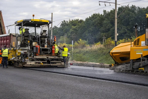 KYIV, UKRAINE - 25 września 2020: Przemysłowa nawierzchnia asfaltowa układająca świeży asfalt na budowie dróg. — Zdjęcie stockowe