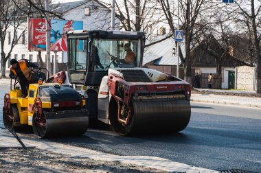 KYIV, UKRAINE - 10 Eylül 2020: Ağır asfalt yol silindirli ağır titreşimli paten sıkıştırıcısı, bir cadde üzerindeki yol inşaatında yeni bir sıcak asfalta baskı yapıyor..