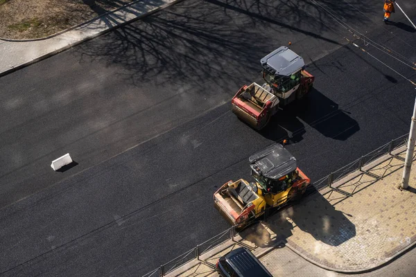 KYIV, UKRAINE - 10 września 2020: Ciężki asfaltowy wałek drogowy z ciężkim zagęszczaczem walców wibracyjnych, który wciska nowy gorący asfalt na jezdni na placu budowy dróg na ulicy. — Zdjęcie stockowe