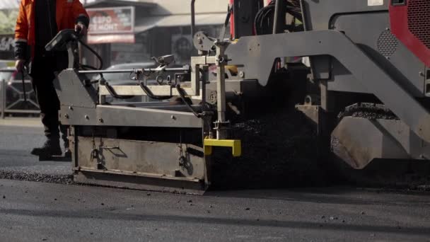 KYIV, UKRAINE - September 10, 2020: Industrial asphalt paver machine laying fresh asphalt on road construction site on the street. — Stock Video