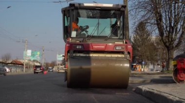 KYIV, UKRAINE - 10 Eylül 2020: Ağır asfalt yol silindirli ağır titreşimli paten sıkıştırıcısı, bir cadde üzerindeki yol inşaatında yeni bir sıcak asfalta baskı yapıyor..