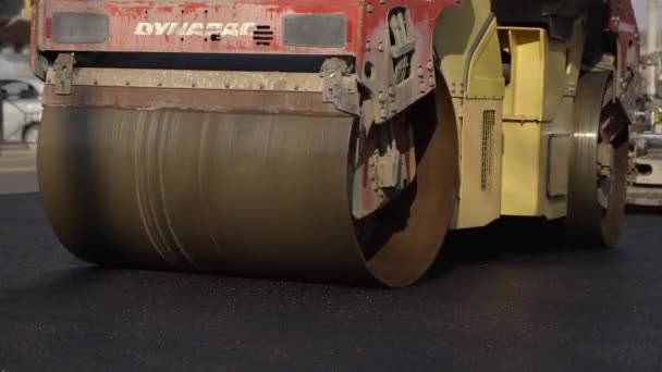 KYIV, UCRANIA - 10 de septiembre de 2020: Rodillo de carretera de asfalto pesado con compactador de rodillos de vibración pesada que presiona el nuevo asfalto caliente en la carretera en un sitio de construcción de carreteras en una calle. — Vídeos de Stock