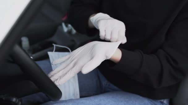 Vrouw met een beschermend medisch masker draagt rubberen handschoenen om zichzelf te beschermen tegen het bacterievirus terwijl ze van plan is te rijden. Beschermend masker tijdens quarantaine, pandemie, covid 19, coronavirus, infectie. — Stockvideo