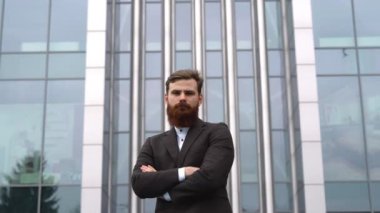 Finans bölgesindeki ofis binasında ceketli yakışıklı bir işadamının portresi. Genç sakallı iş adamı. Resmi giyinmiş başarılı bir girişimci..