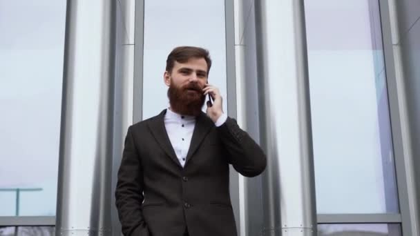 Businessman talking on the phone in financial district. Portrait of a Young urban professional man using smart phone over office building. Business man talking on his smartphone outdoors. Technology. — Stock Video