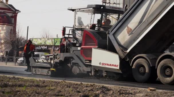 KYIV, UKRAINE - September 10, 2020: Industrial asphalt paver machine laying fresh asphalt on road construction site on the street. — 图库视频影像