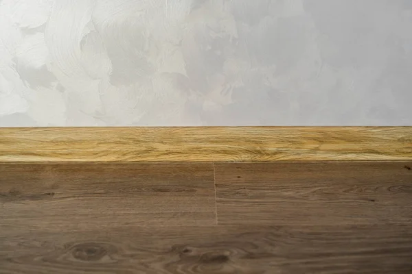 Laminato con battiscopa in plastica con texture in legno. Pavimenti in laminato di legno di recente installazione e battiscopa in casa. Design moderno. Primo piano di plinti di plastica su parquet in legno scuro di quercia. — Foto Stock