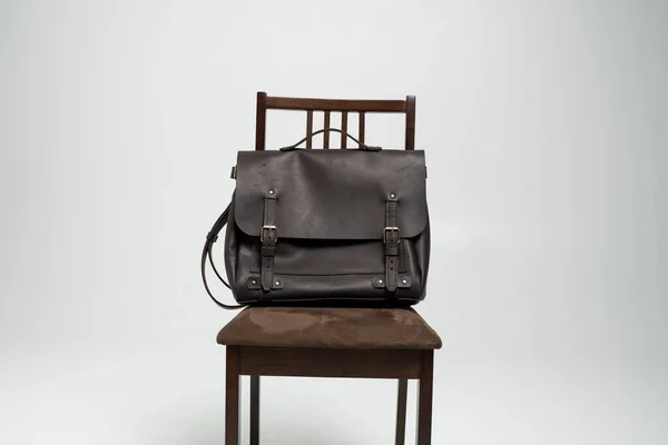 Brown mens bolsa de couro ombro para um documento e laptop em uma cadeira marrom com um fundo branco. Mens caso breve de couro, sacos de mensageiro, bolsa de couro, pasta artesanal. — Fotografia de Stock