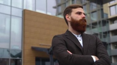 Finans bölgesindeki ofis binasında ceketli yakışıklı bir işadamının portresi. Genç sakallı iş adamı. Resmi giyinmiş başarılı bir girişimci..