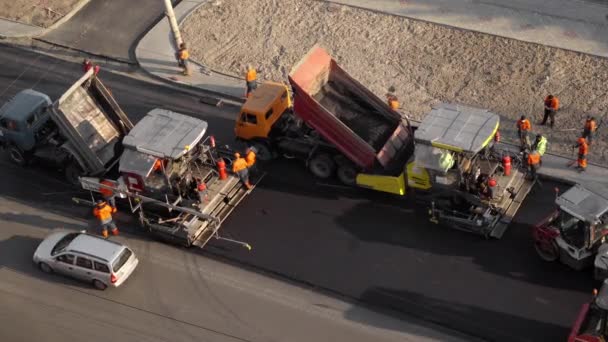 KYIV, UKRAINE - 2020 년 9 월 10 일: 도로 건설 현장에서 새로운 뜨거운 아스팔트와 아스팔트 주조기를 누르는 무거운 진동 롤러. — 비디오