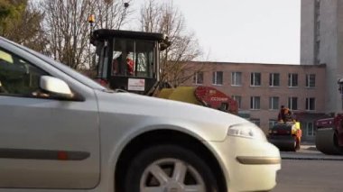 KYIV, UKRAINE - 10 Eylül 2020: Ağır asfalt yol silindirli ağır titreşimli paten sıkıştırıcısı, bir cadde üzerindeki yol inşaatında yeni bir sıcak asfalta baskı yapıyor..