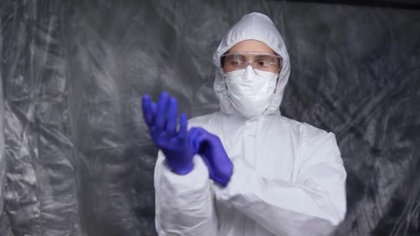 El médico con traje protector blanco, máscara, gafas y guantes de goma está listo para ayudar a un pueblo mientras amenaza la pandemia de coronavirus. Epidemia, pandemia de coronavirus covid 19. Doctor en respirador. — Vídeos de Stock