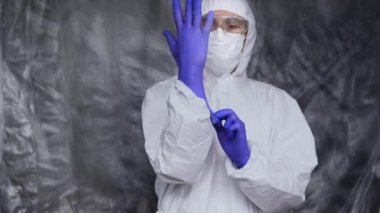 Beyaz koruyucu giysili, maskeli, gözlüklü ve lastik eldivenli doktor koronavirüs salgını tehdidi altındaki insanlara yardım etmeye hazır. Salgın, Coronavirus covid 19 salgını. Solunum cihazındaki doktor..